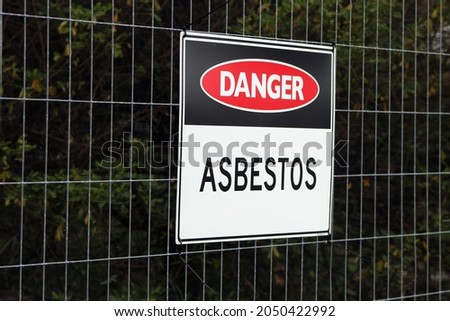 Asbestos warning sign on fence
