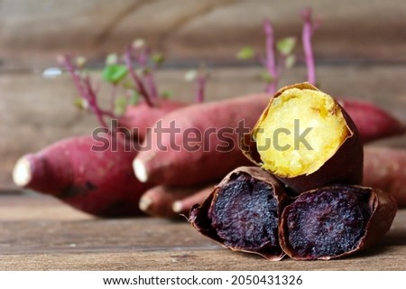 Sliced of baked sweet potato yellow and purple texture inside fresh potato on old wood texture background