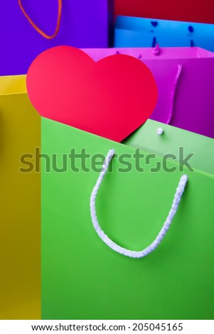 Colourful paper shopping bags with red heart. Yellow, violet, red, blue, pink and green shopping bags.