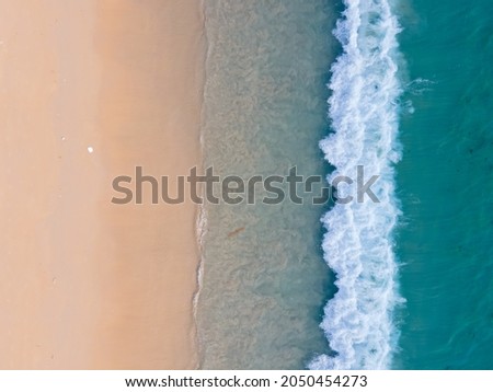 Aerial view high angle view Top-down seawater wave on sandy beach. Aerial view above beach sea in tropical beach sea. Royalty-Free Stock Photo #2050454273