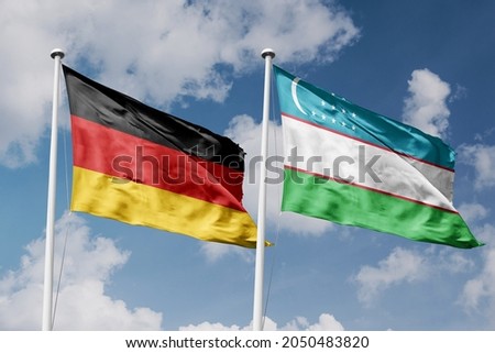 Germany and Congo Democratic Republic two flags on flagpoles and blue cloudy sky background