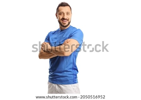 Portrait of a young male athlete in a blue jersey posing with crossed hands isolated on white background