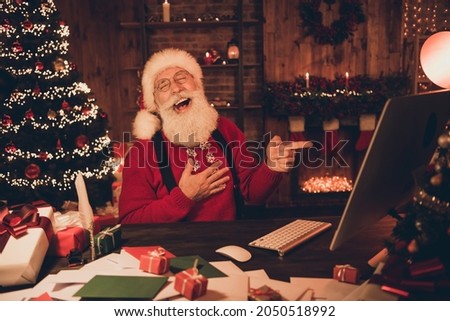 Photo portrait cheerful smiling santa pointing finger on computer screen laughing happy