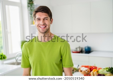 Portrait of attractive cheerful guy cooking meal spending free time domestic restaurant staying at home kitchen indoors