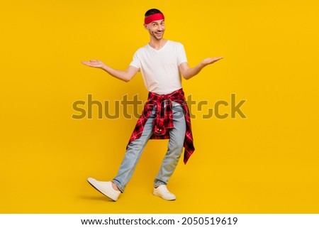 Full length photo of happy man wear plaid shirt on waist hands scales empty space isolated on yellow color background