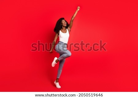 Full size photo of young attractive black girl happy positive smile look empty spae superhero isolated over red color background