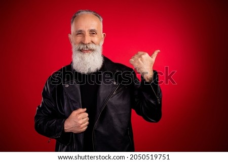 Portrait of attractive cheerful grey-haired man showing copy empty space look isolated over bright red color background