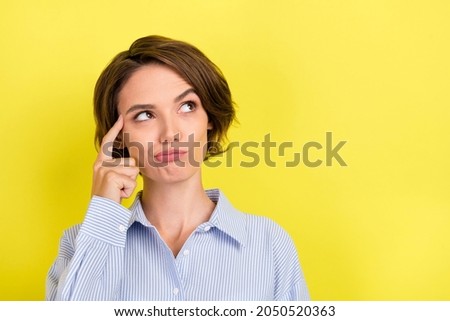 Photo of young attractive woman finger touch head think memory idea look empty space isolated over yellow color background