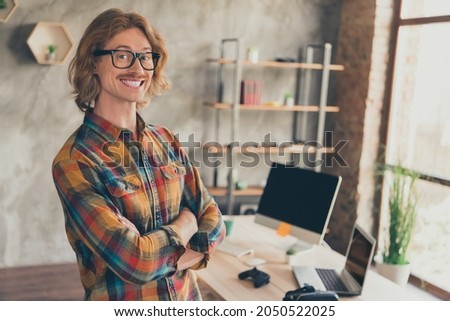 Photo portrait man in glasses checkered shirt folded hands professional developer at office smiling happy Royalty-Free Stock Photo #2050522025