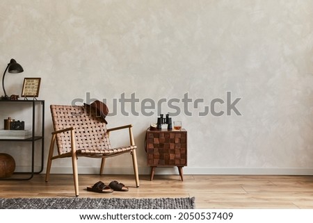 Stylish interior design composition of elegant masculine living room with copy space, brown armchair, designed commode, industrial shelf and personal accessories. Template.   Royalty-Free Stock Photo #2050537409
