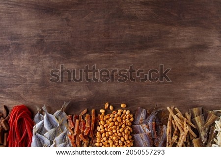 Wooden brown background with snacks for beer: fish, crackers, nuts, copy space