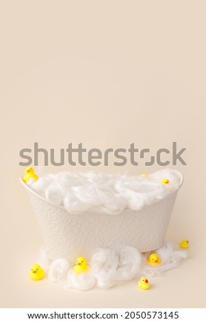 White small bath for a photo shoot of a child on a light background, decorated with ducks.