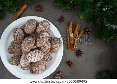 Christmas biscuits close up photo. Fir tree branches, anise stars, cinnamon sticks pine cone shaped cookies. 