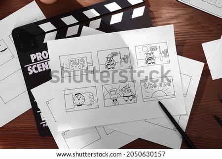 Storyboard with cartoon sketches at workplace, flat lay. Pre-production process
