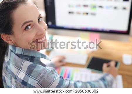 Portrait of smiling woman designer working at computer