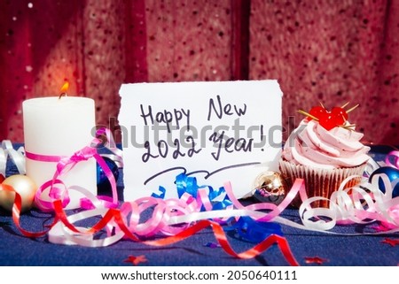 Happy new year 2022 - celebration card with cupcake, candle and decorations