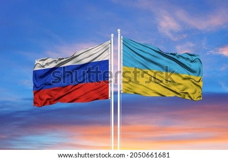 Ukraine and Russia two flags on flagpoles and blue sky Royalty-Free Stock Photo #2050661681