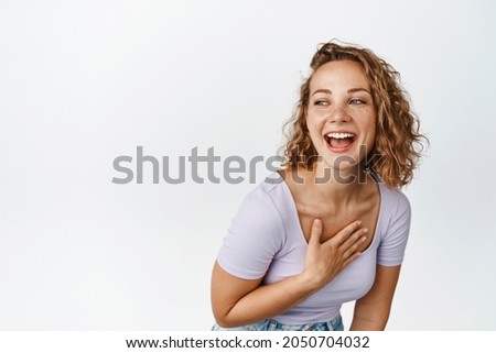 Lifestyle and people. Happy blond woman laughing, looking aside with carefree smiling face expression, standing over white background