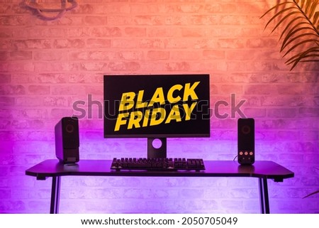 Black Friday background with computer gamer workspace with black screen monitor with neons and colorful lights. Gamer Rig.