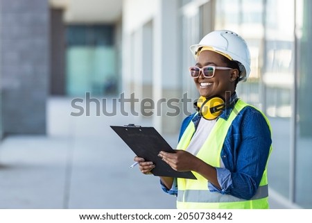 Adult female builder, engineer, architect, inspector, manager at construction site. Woman with plan, clip board. Portrait of smart female engineer inspector hand hold paper chart inventory checking Royalty-Free Stock Photo #2050738442