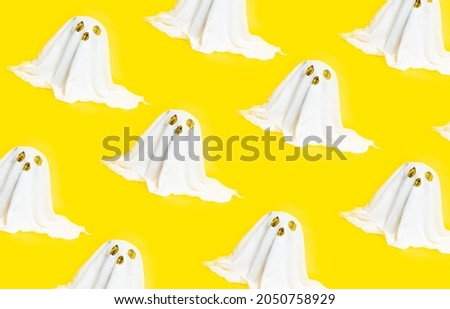 Pattern of white ghosts isolated on yellow background.