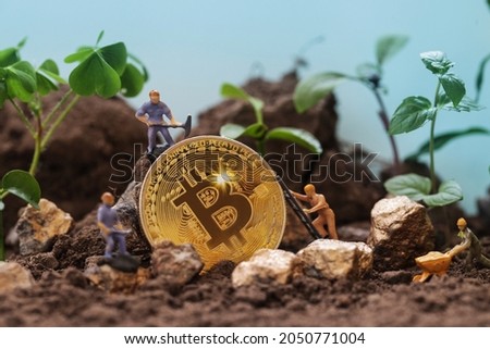 Environmental, Social and Governance. Renewable Cryptocurrency Mining. Miner figurines digging ground to uncover big Gold bitcoin. Eco-friendly cryptocurrencies. Royalty-Free Stock Photo #2050771004