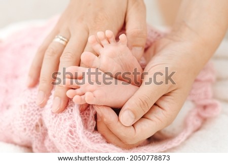 Baby feet in mother's hands. The feet of a tiny newborn baby have a close-up of hands formed on them. Mom and her child. Happy family concept. Beautiful conceptual image of motherhood