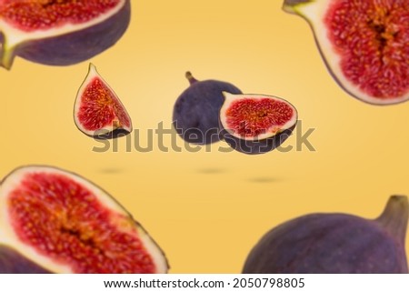 Fresh ripe whole and sliced figs flying in air isolated on pastel yellow background. Creative and minimal food concept. Vegetarian diet idea.