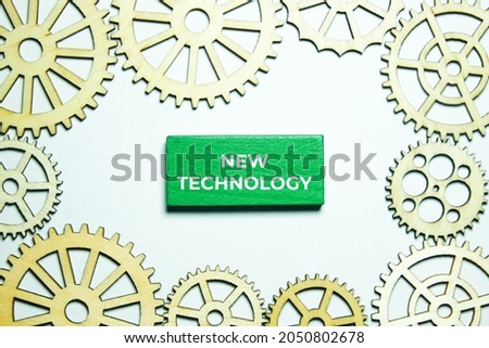 A picture of new technology on green wood with wooden gear. New technology emerge every year.