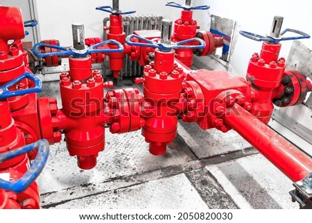 Petroleum oil and gas drilling equipment. Choke and kill manifolds are wellhead equipments that are assembled on the blowoul preventer units. Piping and valve system on offshore wellhead platform. Royalty-Free Stock Photo #2050820030