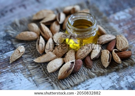 Selective focus. Macro. Almond oil in a jar. Almonds in shells.