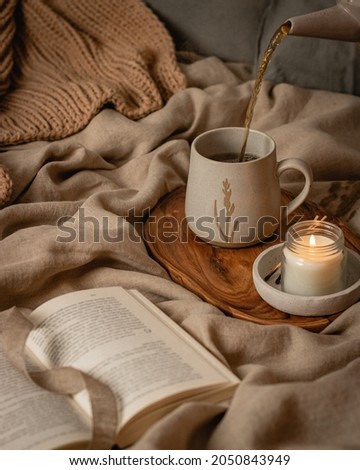  teapot and tee cup on the window in room with candle cozy autumn still life slow living fall pumpkin. High quality photo Royalty-Free Stock Photo #2050843949