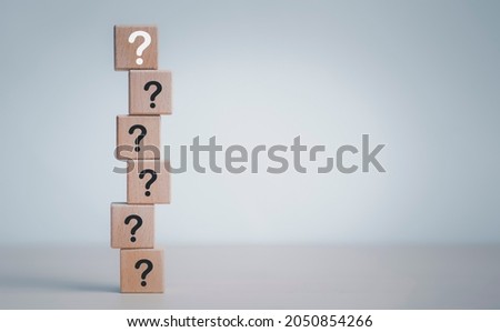 Hand hold Wooden cube block in question mark mean what on cement table background, column of wooden blocks with question sign mark. copy space,FAQ frequently asked questions, Answer, Information Royalty-Free Stock Photo #2050854266