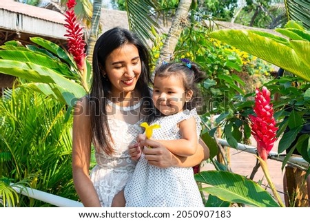 Outdoor Portrait in the park, around the river. Mother embracing her daughter.