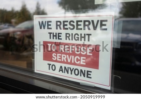 Storefront sign at a restaurant that says, "We reserve the right to refuse service to anyone."