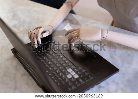 wooden hands using a laptop in the office