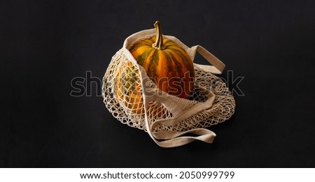 Fresh pumpkins in an eco-friendly mesh shopping bag. Eco-friendly natural cotton bag. Reusable eco-friendly shopping bag. Zero waste concept. Plastic-free products.