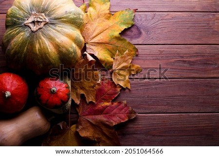 Festive autumn decor from pumpkins and leaves on a brown wooden background. Concept of Thanksgiving day or Halloween. Flat lay autumn composition with copy space.