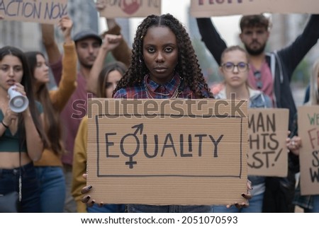 Multiracial group of young people walking together protesting for equality against racism  Royalty-Free Stock Photo #2051070593