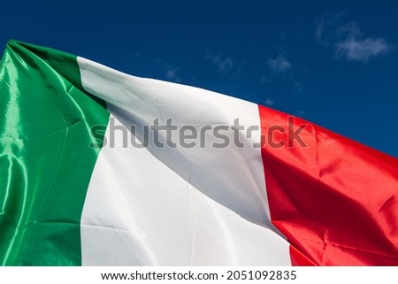 Italian flag waving against the blue sky