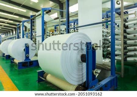 Packaging bag production workshop, The production workshop of woven belt, A factory workshop where textile belts are produced Royalty-Free Stock Photo #2051093162
