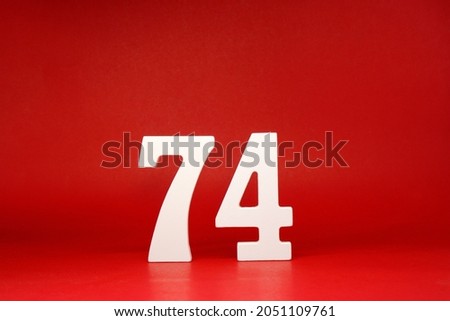 Seventy Four ( 74 ) white number wooden Isolated Red Background with Copy Space - New promotion 74% Percentage   Business finance or birthday Concept - advertise banner picture online with copy space