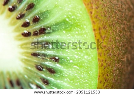 Macro Fruit: extreme close-up of a ripe kiwi fruit, black background, horizontal format