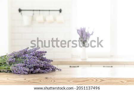A bouquet of lavender in the interior of a stylish kitchen. Vertical frame mockup on a wooden table