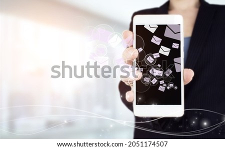 Sending email.Bulk mail.Hand hold white smartphone with digital hologram Email and sms sign on light blurred background. Email marketing concept. Sending newsletter.