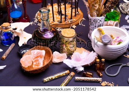 Witchcraft still life with black burning candles selective focus. Esoteric gothic and occult witch table for Halloween. Various magic objects and ritual arrangement. Gothic Halloween. 
