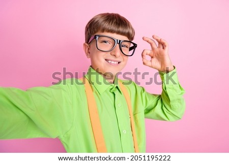 Photo of young school boy age record video show okay alright deal symbol choose ads isolated over pink color background