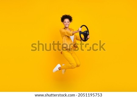 Full length body size photo woman jumping keeping steering wheel isolated vivid yellow color background Royalty-Free Stock Photo #2051195753