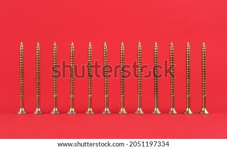 Metal screws on a red background