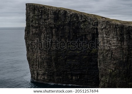 Cliffs of Faroe Islands  Blue ocean below the cliffs  Towering black cliffs on the coast of Faroe Islands Royalty-Free Stock Photo #2051257694